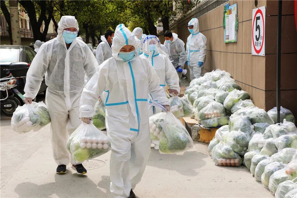 3月28日，上海市奉贤区西渡街道鸿宝一村（南区）的志愿者为居民送菜。新华社发（王燕婷 摄）