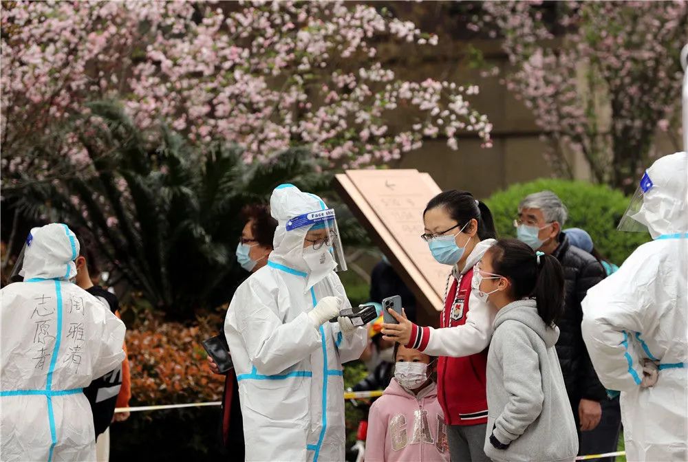 3月27日，在上海市松江区某封控小区内，志愿者为居民进行核酸检测登记。新华社记者刘颖摄