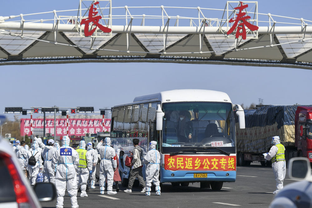 在吉林长春高速公路东出口，返乡农民登上返乡公交专线（4月12日摄）。新华社发