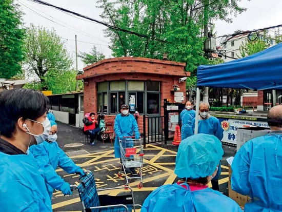 4月14日，华师大二村志愿者再小区大门内等待分发物资。图/受访者提供