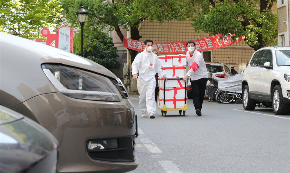 上海市闵行区七宝镇社区志愿者施忠良（左）与他的志愿者伙伴一起为居民派送生活物资（4月11日摄）。新华社记者 方喆 摄