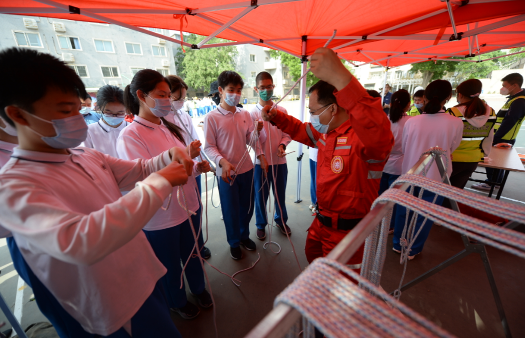 ▲5月10日，在北京市第一五六中学，教官向学生们演示如何制作逃生绳结。新京报记者 王嘉宁 摄